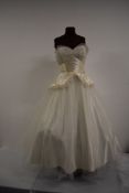 A 1950s strapless wedding or evening dress having peplum waist and tulle layers over satin