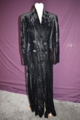 A late 1920s/ early 1930s black velvet full length coat having cream lining and four self covered