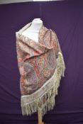 A Victorian printed shawl, having Paisley pattern and fringing to edges.