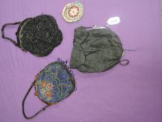 Three Victorian and Edwardian evening bags and a coin purse, black silk drawstring bag with