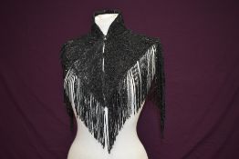 A stunning short Victorian beaded capelet having stand-up collar and lengths of beadwork tassels.