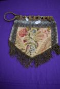 A Victorian bag having drawstring fastening, metallic lace and tassel detailing and floral panels.