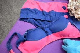 A pair of 1950s shorts, a sun top, floral rubber swimming cap and a bikini and towelling skirt wrap,