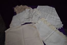 A mixed lot of vintage and antique table linen and a child's dress.