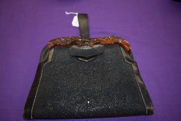 An unusual striking black leather Art Deco clutch bag having moulded eagle shaped faux tortoiseshell