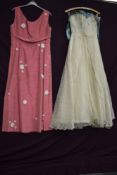 A pink 1960s maxi dress having daisy details and a 1950s lace Wedding dress, later slightly