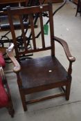 A 19th Century oak kitchen armchair having rail back and solid seat