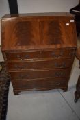 A modern bureau in mahogany with four drawer base