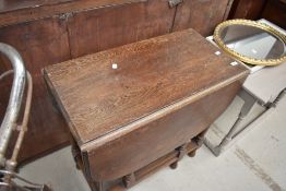 An early 20th century oak drop leaf gate leg dining table