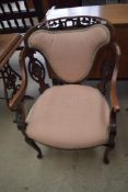 A late Victorian armchair having shaped frame, upholstered back and seat on cabriole legs