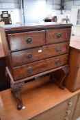 A reproduction mahogany chest of two over two drawers, on cabriole legs, small proportions, width