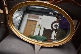 A reproduction gilt frame oval wall mirror