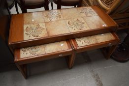 A vintage teak and tile top coffee table with nesting pair under