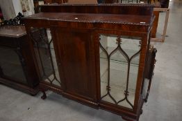 An early 20th Century mahogany display case having central cupboard flanked by glazed display
