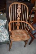 A traditional stained frame Windsor chair having crinoline stretcher