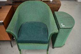 A painted green wicker Lloyd Loom style laundry basket and a basket chair/commode, dated 1950.