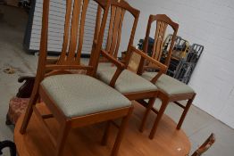 A vintage part teak extending dining table and seven (six plus one) dining chairs