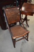 An antique rocking chair having wood back with cut out detailing to form a pattern.