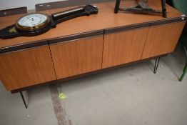 A 1960s E Gomme G Plan sideboard having four doors to two compartments and later hair pin legs.