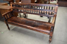 A Victorian mahogany settle/bench having turned spindle back and sides