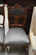 Four Edwardian chairs having intricately carved backs and serpentine fronted seat base, with