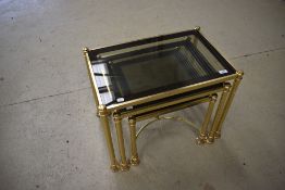 A vintage nest of brass and glass tables