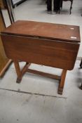 An Arts and Crafts oak drop flap occasional table (foot off)