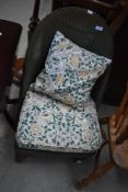 A Lloyd Loom low seat nursing or similar chair with later upholstered cushions