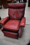 A mid century reclining arm chair or lazy boy having blood red leather