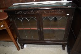 A 20th century dark oak book case having leaded light doors