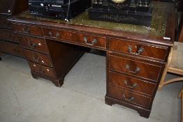 An antique mahogany key hole desk having green leather to top and three over six drawers.