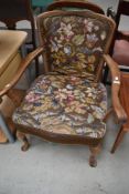 An early 20th Century stained frame armchair having woolwork seat and back , having scroll arm ,