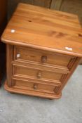 A modern pine three drawer bedside chest