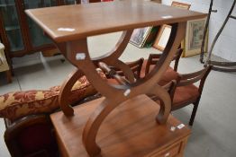 A vintage teak occasional table having stylised frame
