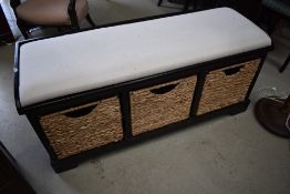 A modern hardwood bench having basket storage under, width approx. 125cm