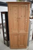 A stripped pine corner cupboard