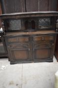 A mid to late 20th century dark oak court cupboard having leaded glazed doors with cupboard and