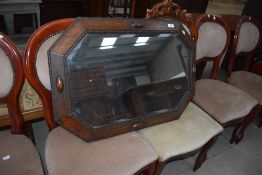 An antique carved oak framed bevelled glass wall mirror.