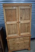 A Victorian stripped pine housekeepers or similar cupboard having later wardrobe interior over three