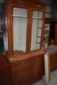 A Victorian bleached mahogany bookcase, having double cupboard base, Aesthetic style handles,