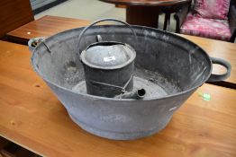 A vintage zinc bath and watering can