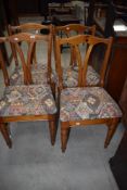 A set of four vintage pine dining chairs having shaped rail backs and turned legs