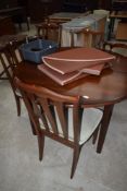 A modern mahogany circular dining table, extendable width four rail back dining chairs