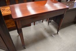A Victorian mahogany fold over dining table, possibly later or refurbished top, on turned legs,