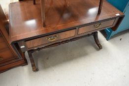 A reproduction coffee table having lions paw feet and double drawer set