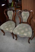 A pair of Victorian mahogany salon chairs having scroll frames overstuffed seats and backs