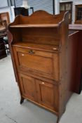 A 19th Century golden oak bureau of shallow proportions with bookshelf over and double cupboard