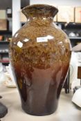 A substantial studio pottery lamp base having mottled brown glaze.