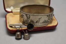 A vintage white metal etched bangle and a bar brooch having bell details, marked silver to rear.