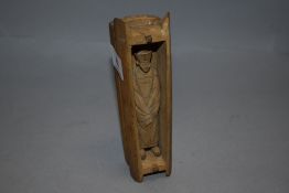 An unusual Japanese wooden carved figure of an official in a coffin